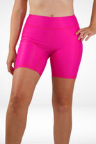 Bright pink athletic shorts worn by a person on a white background