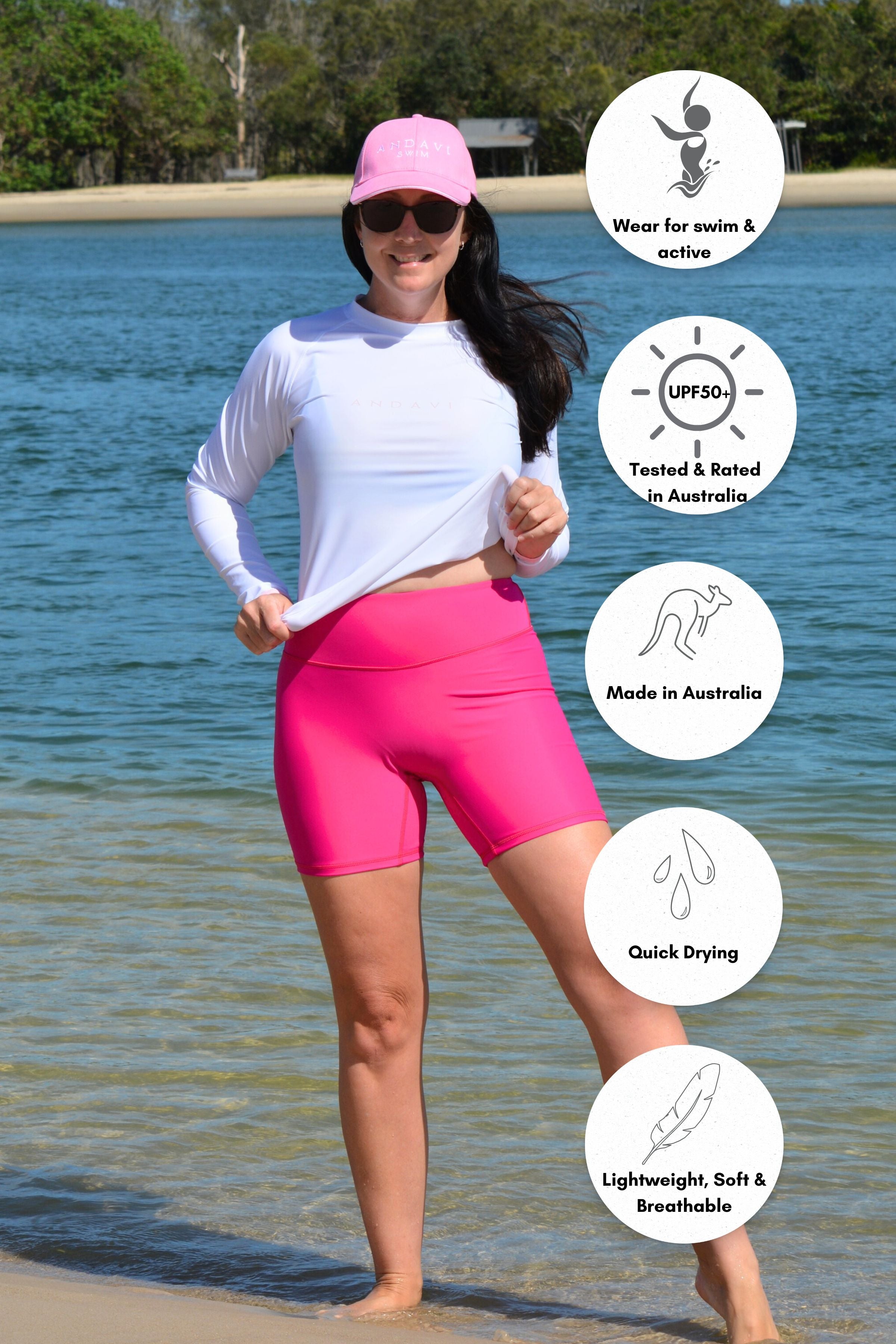 Woman wearing a white long-sleeve shirt and pink shorts on a beach, with product features displayed.