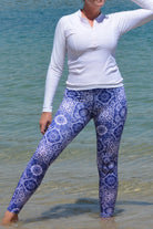 women wearing white andavi long sleeve rash guard and white and blue print andavi swim leggings