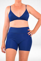 model wearing dark blue swim active bike shorts with mid calf length leg and matching traingle bra bikini top