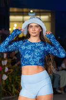 women wearing white and blue rash guard with light blue swim shorts and bucket hat