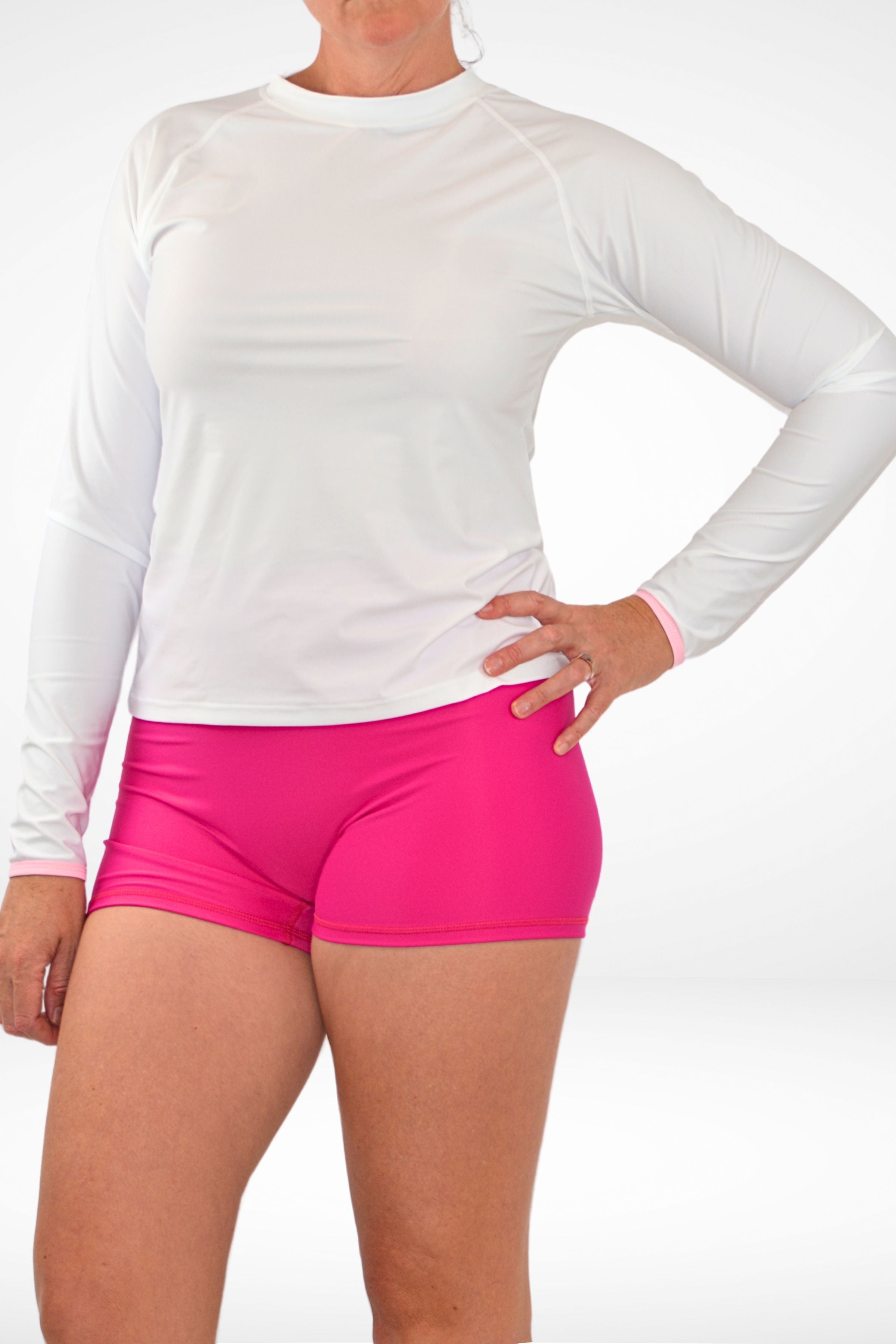 model wearing white andavi rash guard and pink shorts 