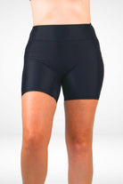 Black athletic shorts worn by a person on a white background