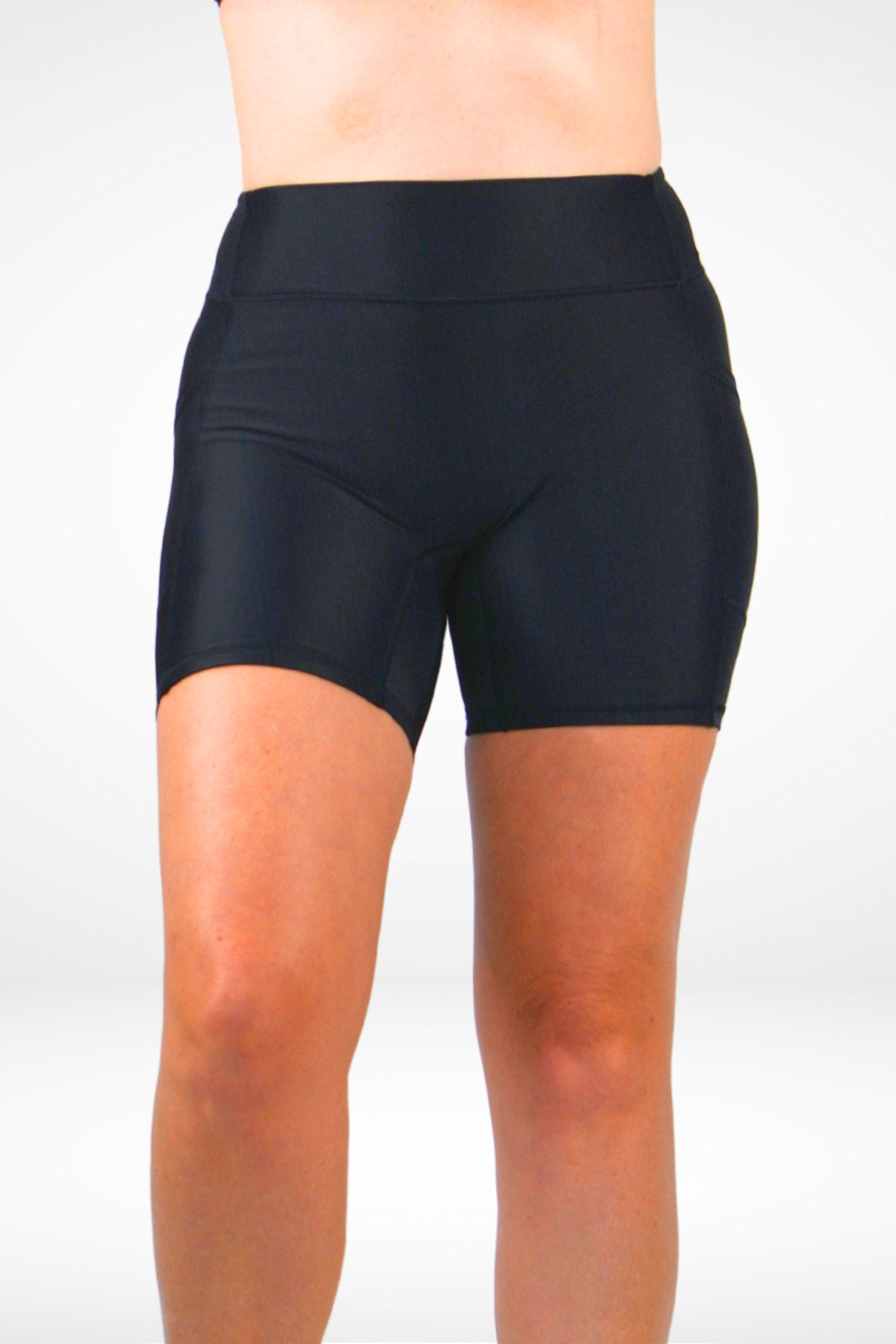Black athletic shorts worn by a person on a white background