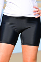 women in black long leg swim shorts