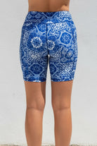Blue patterned shorts worn by a person against a white background